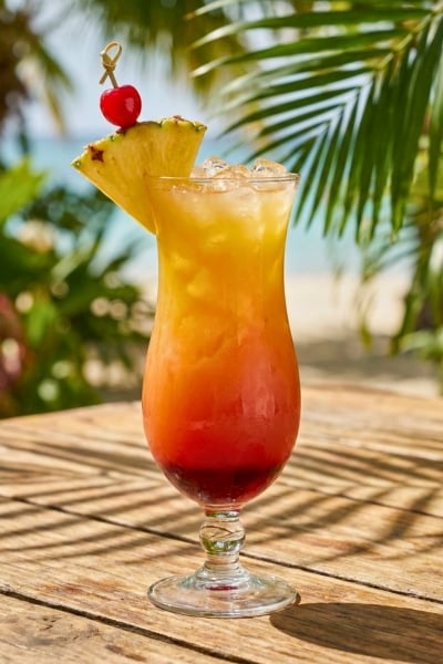 tropical rum punch met ananas en rood fruit garnish