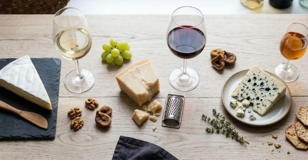 verschillende kazen met bijpassende wijnglazen op tafel